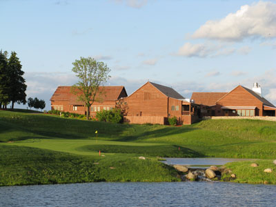 The barn-looking clubhouse frames the back of the 18th at Windsong Farm